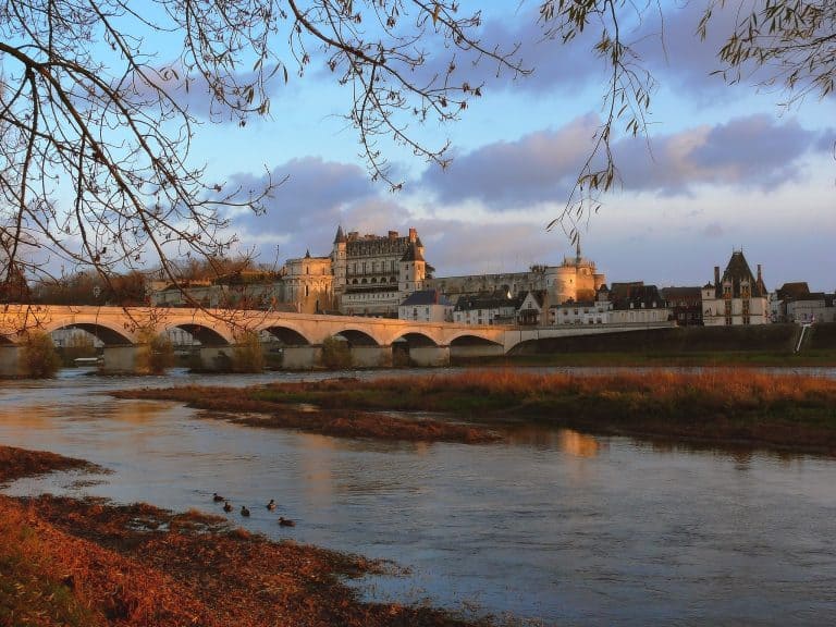 Chateau Royal d'Amboise seen from across the Loire River with the bridge leading to town in the foreground.