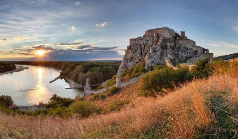 Devin Castle in Slovakia during golden hour with the sun setting over the Danube River. An easy day trip from Bratislava!