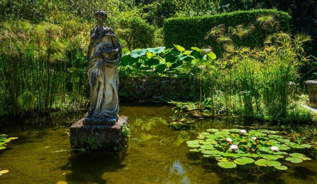 15 Best Things to do in Menton, France 7 Jardin Serre La Madone with a small pond and eerie looking statue in Menton, France.