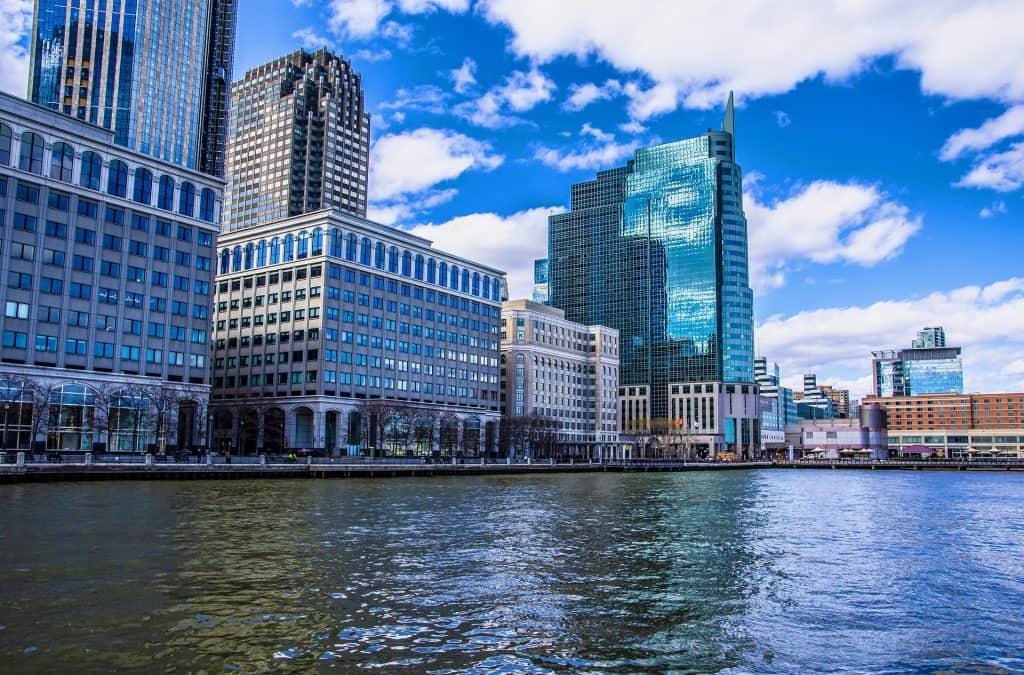 23 Affordable Weekend Getaways in the United States 12 Jersey City Docks, buildings reflected on water.