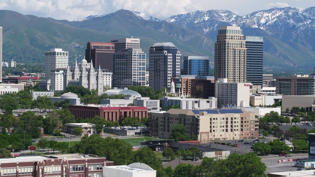 23 Affordable Weekend Getaways in the United States 19 Snow covered mountains behind the landscape of Salt Lake City, Utah, one of the most underrated US cities
